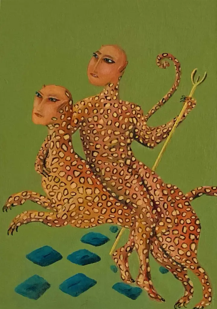 A mythological creature rides on top of another mythical creature. They hold a staff in their hand. They both have tails. They have orange coloured fur like a leopard with human faces. They both have tails